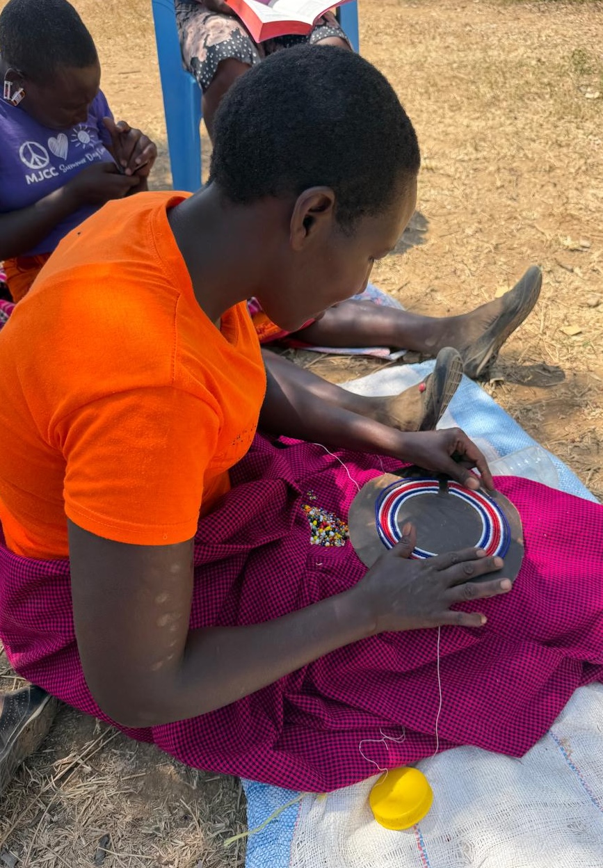 Mary creating traditional Maasai beadwork with colorful thread and beads